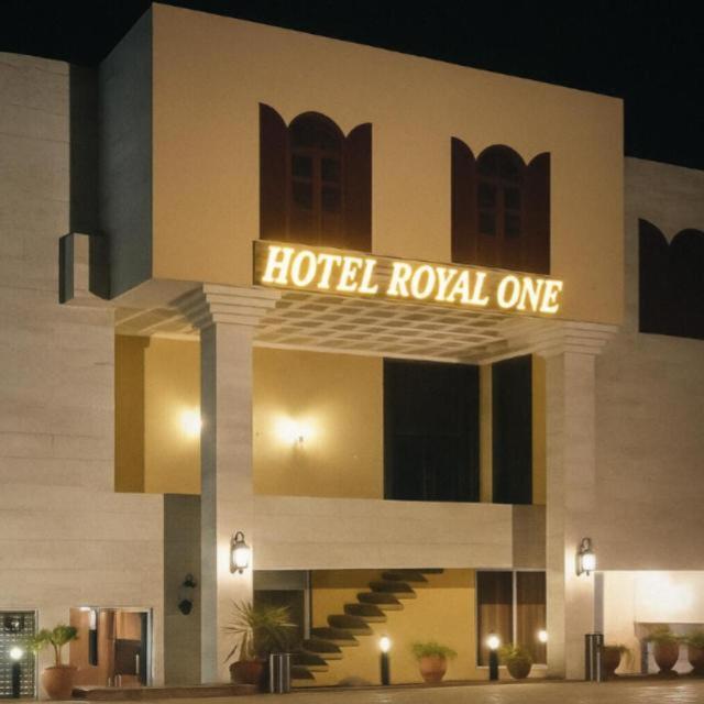 a hotel lobby with a hotel royal entrance at night at Hotel Royal One in Multan