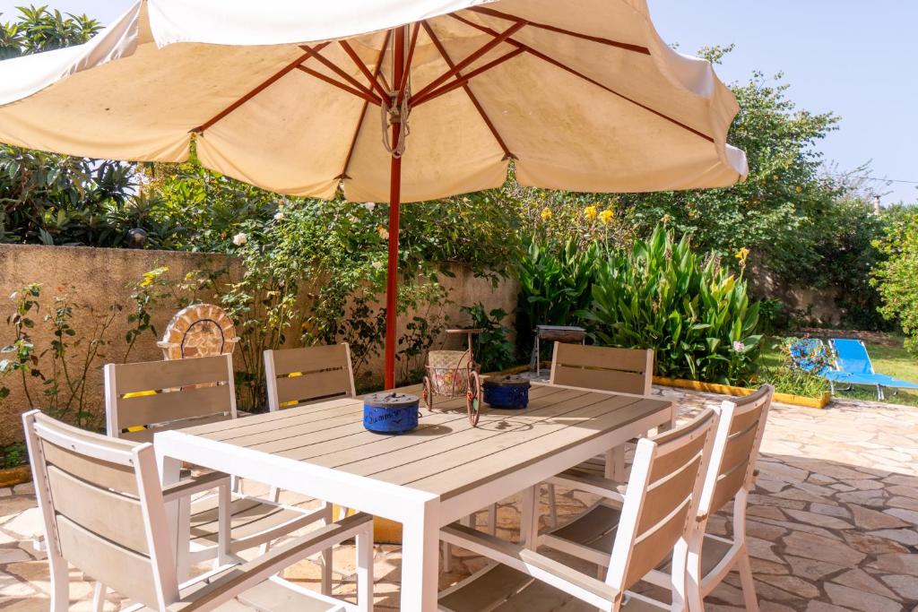 a wooden table with an umbrella and chairs at Princess House in Sidari