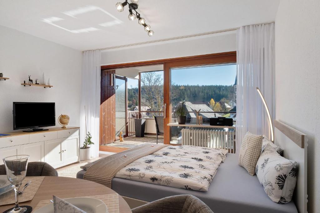 a bedroom with a bed and a large window at Fw Moonlight mit Sauna, Schwimmbad in Schönwald