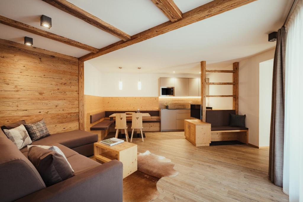 a living room with a couch and a kitchen at Chalet La Flüta Arnica in La Valle