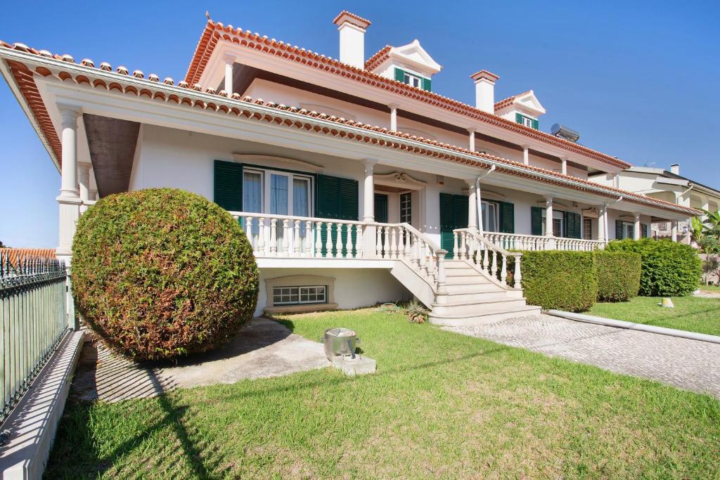 a large white house with a porch and bushes at Casa Imaginário Com Serenidade in Caldas da Rainha