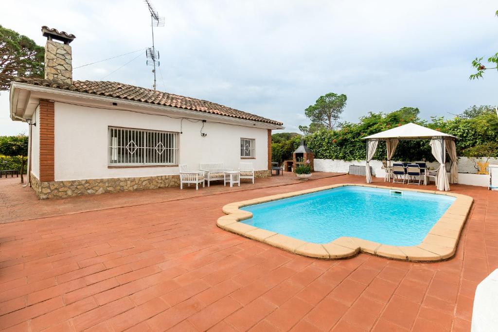 a patio with a swimming pool and a house at Can Fogars in Fogás de Tordera