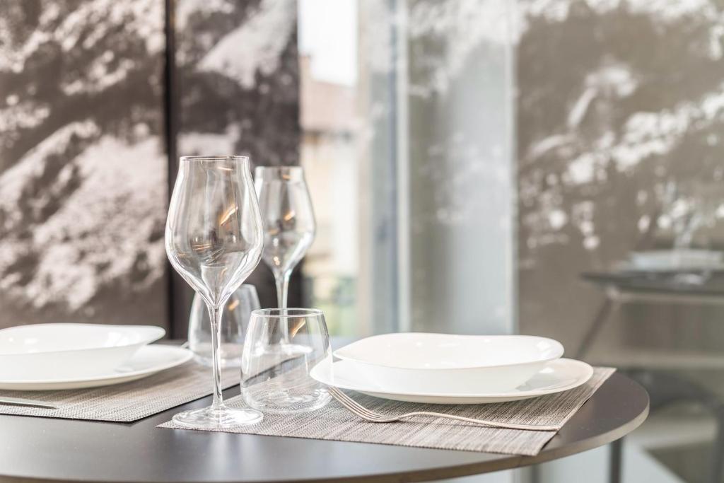 a table with wine glasses and plates on it at Mandello amorevole dimora in Lecco in Lecco