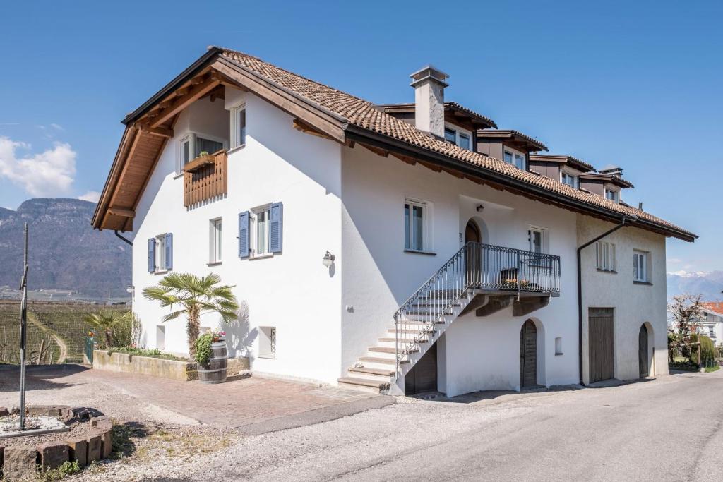a white house with a staircase on the side at Valtlhof - Apt 1 in Cornaiano