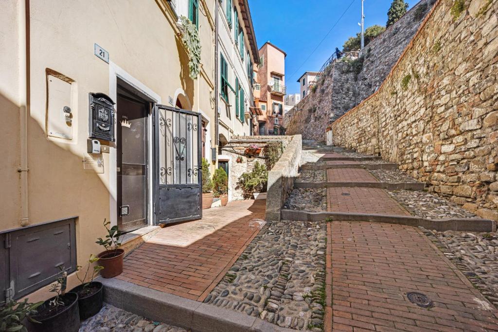an alley with a stone wall and a door at Domus Regina Elena in Sanremo