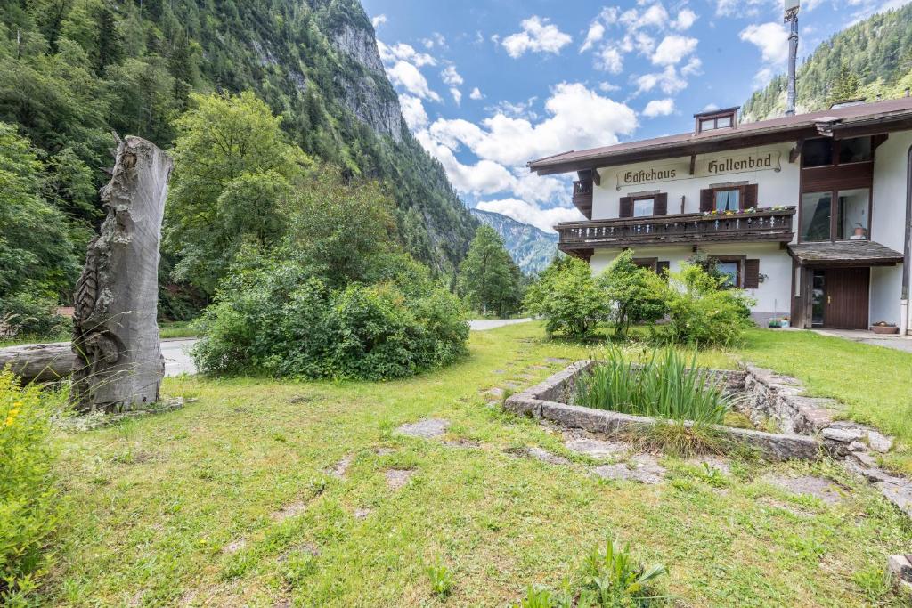 a building in a field next to a mountain at Ferienwohnung Förchensee in Ruhpolding
