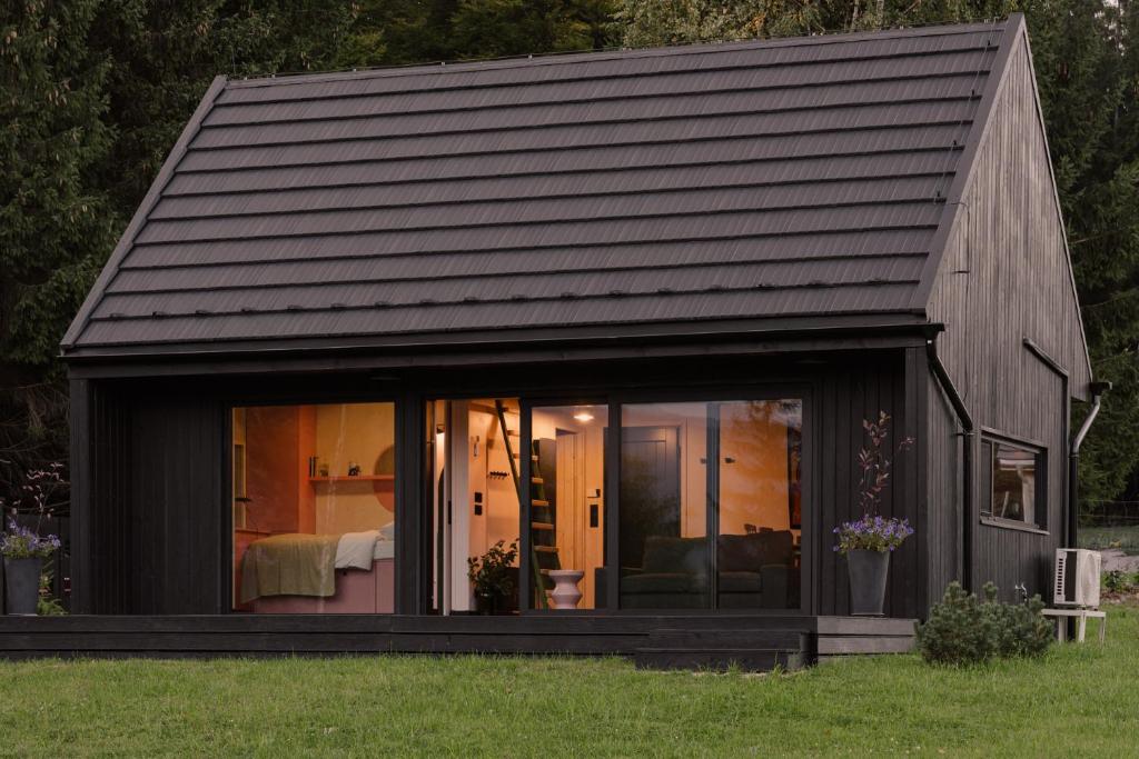 a small black house with a roof at laba in Lasowka