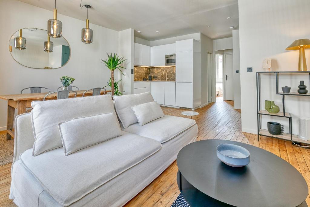 a living room with a white couch and a table at Appartement Le Dauphin in Pornichet