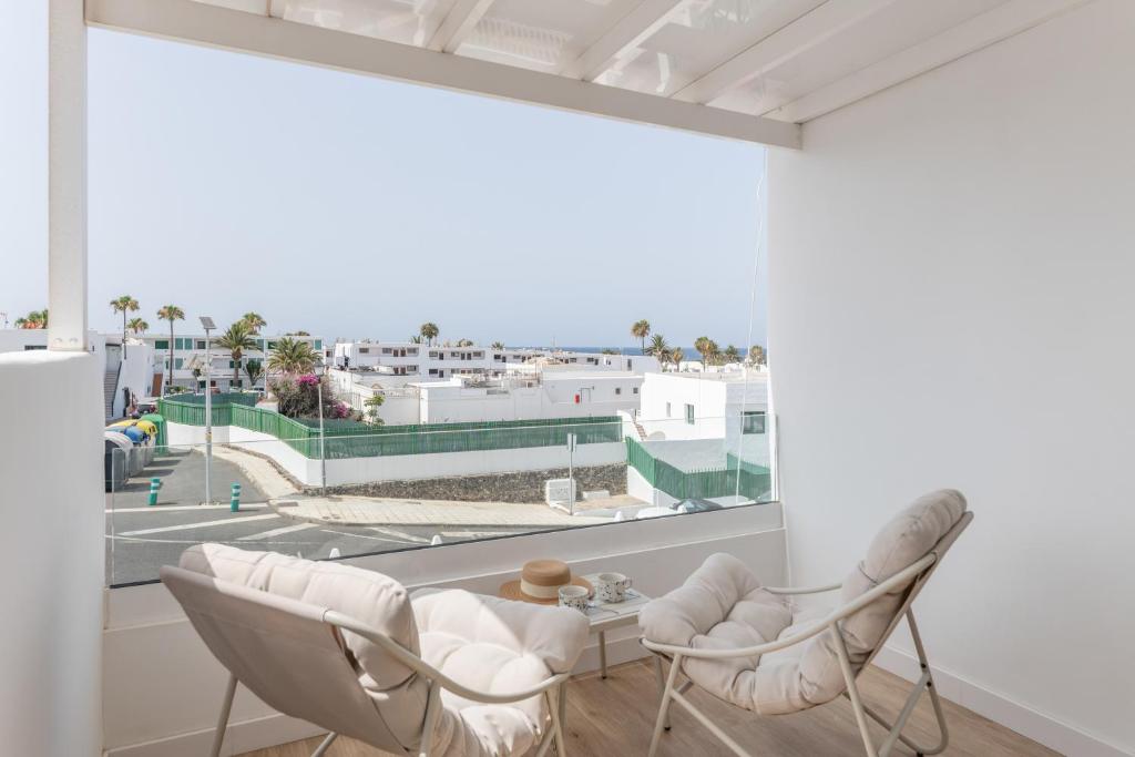 a living room with white furniture and a large window at Casa Ancla in Tías