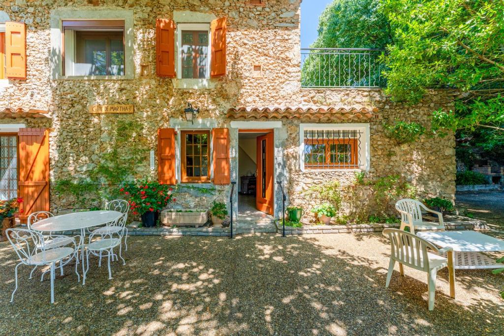 a stone house with a table and chairs in front of it at Gîte Chez Martha in Anduze