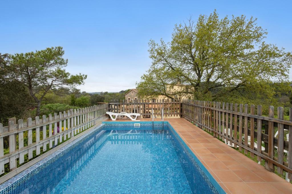 a swimming pool on a fence with a table and a bench at Cal Panxeta in Balsareny