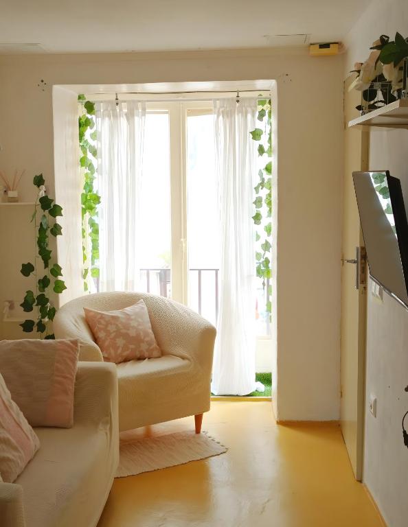 a living room with a couch and a large window at Ca Les Nines 2 in Pinell de Bray