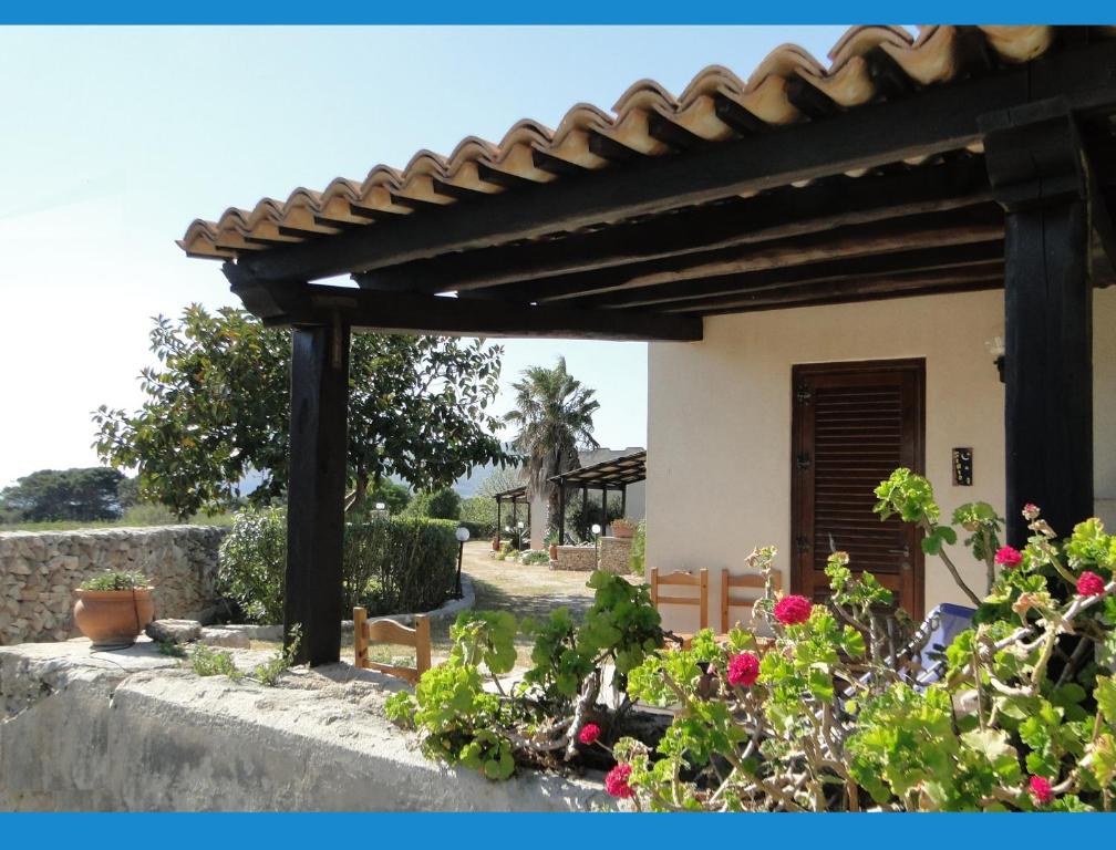 a wooden pergola in front of a house with flowers at Isola Di Favignana in Favignana