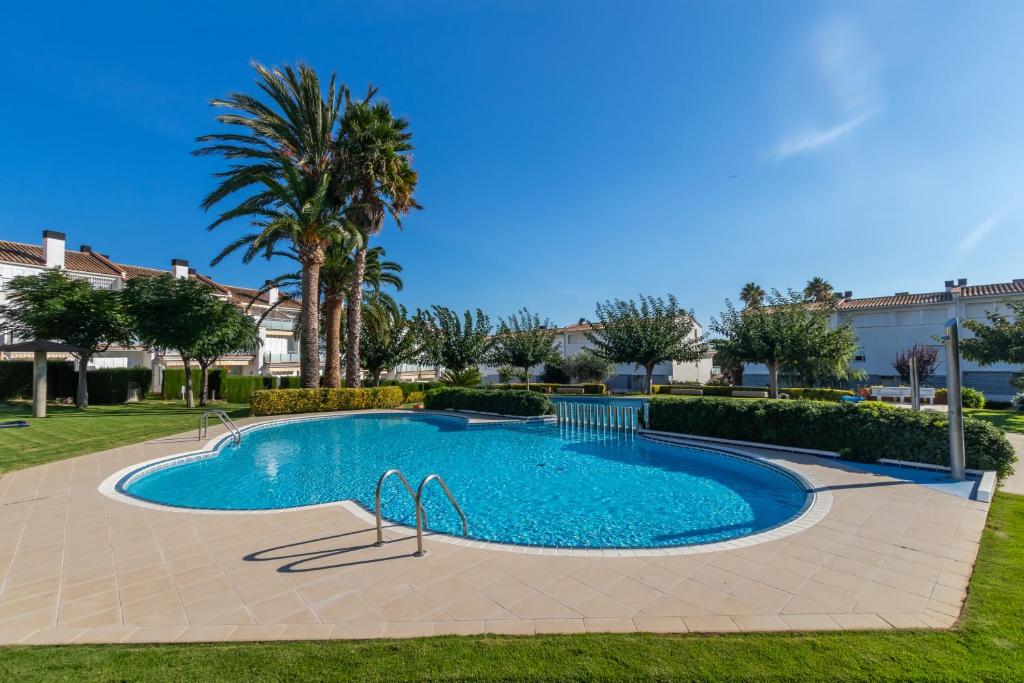 a swimming pool in a yard with palm trees at Fantàstic s'agaró in S'agaro