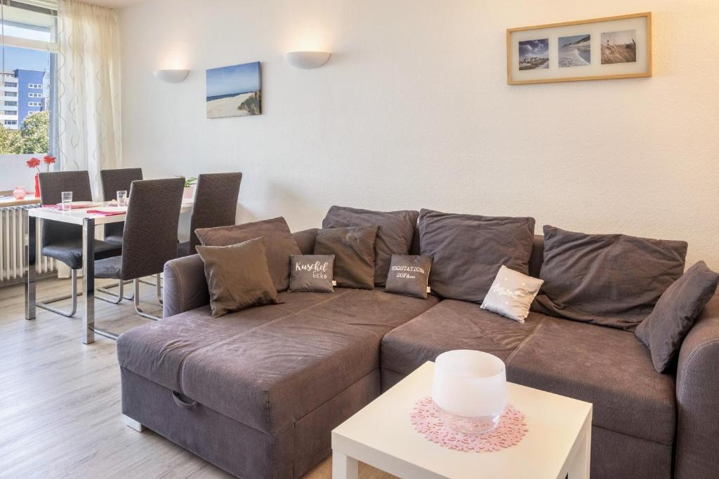 a living room with a brown couch and a table at Ferienpark N3 -3 in Heiligenhafen