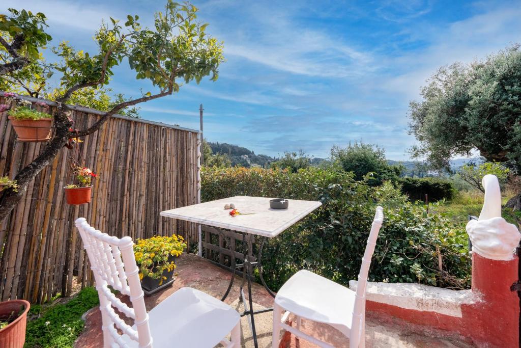 a small table and chairs in a garden at Grenta Country House in Corfu