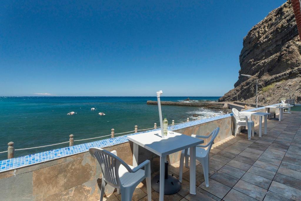 a table and chairs on a balcony overlooking the ocean at Apartamentos Playa Azul - 5 in Vallehermoso