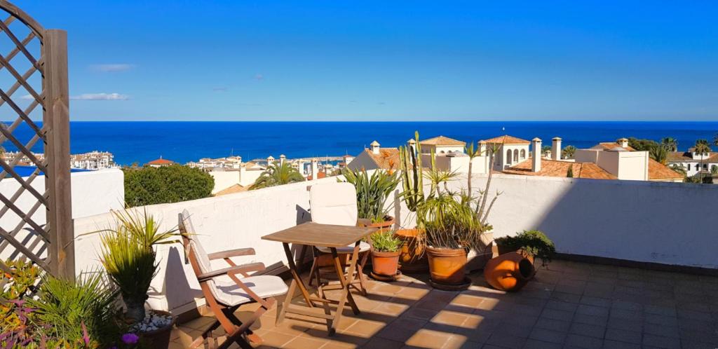 a patio with a table and chairs and the ocean at La Terraza del Mar in Manilva