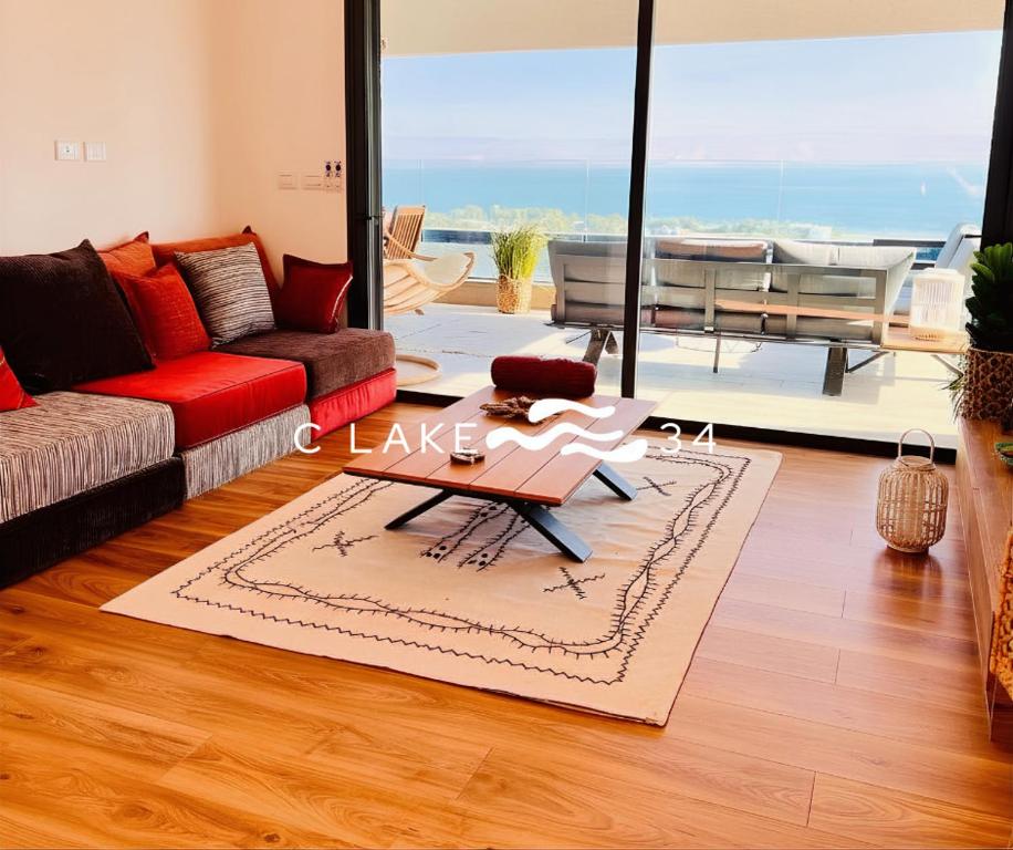 a living room with a couch and a table at 34-C Lake, מתחם סי כנרת in Migdal