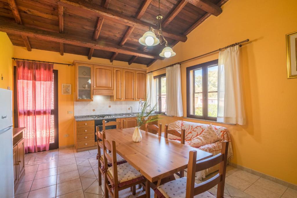 a kitchen and dining room with a wooden table at Quadrilocale 800mt dal mare in San Teodoro