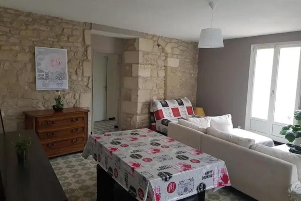 a living room with a couch and a table at Apt T3 - 3 Min du Futuroscope in Chasseneuil-du-Poitou