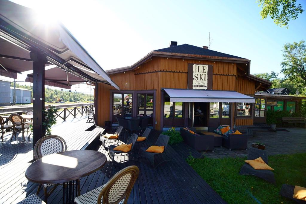 a patio with tables and chairs and a building at Le Ski Lodge & Steakhouse in Storlien