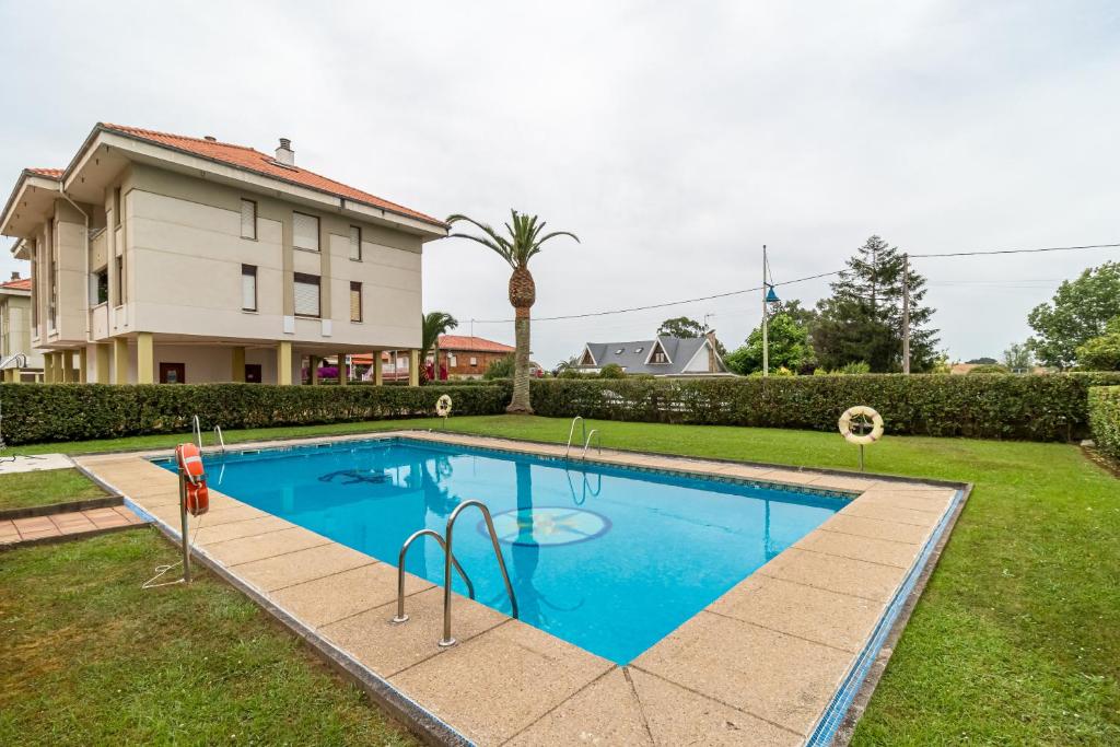 a swimming pool in the yard of a house at Apartamento La Ribera in Suances