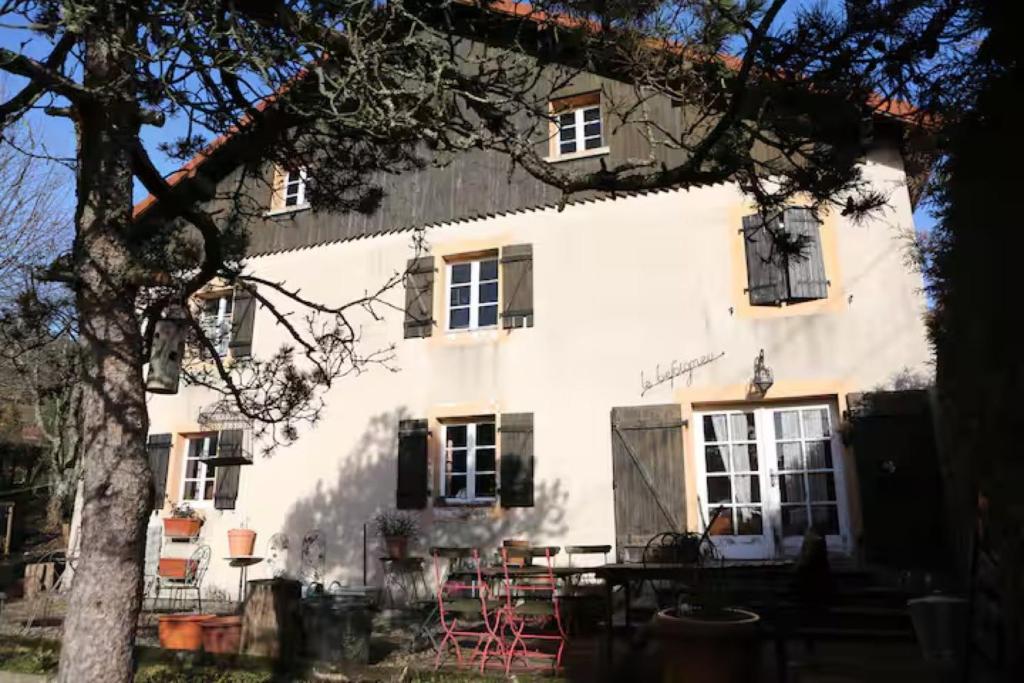 a white building with red chairs in front of it at Gite - Le befoigneu in Ferdrupt