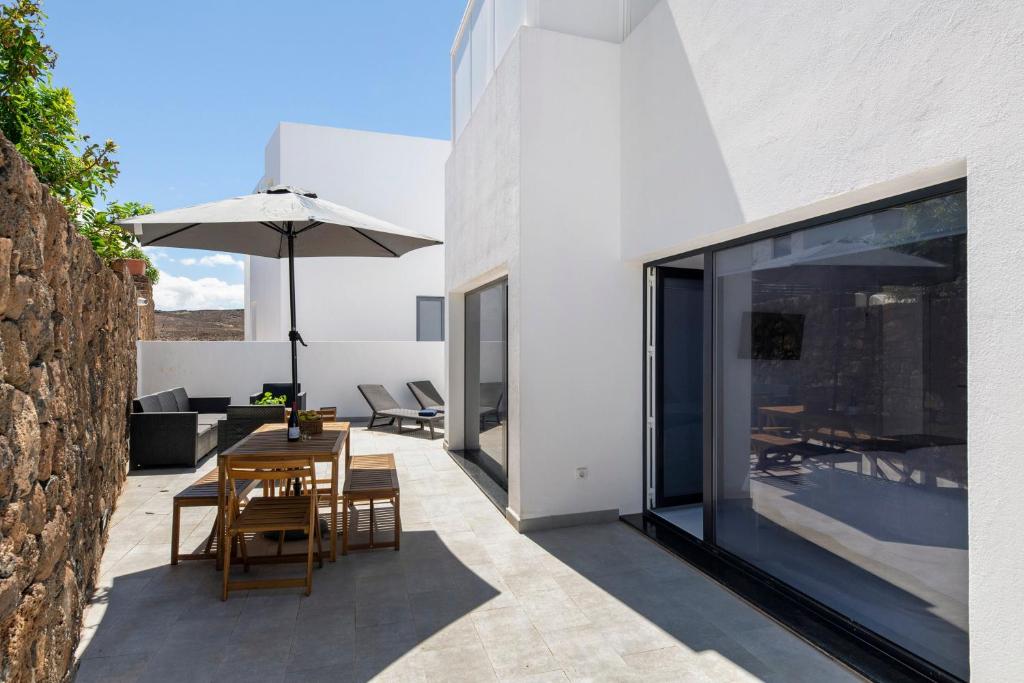 an outdoor patio with a table and an umbrella at Noray 2 in La Santa