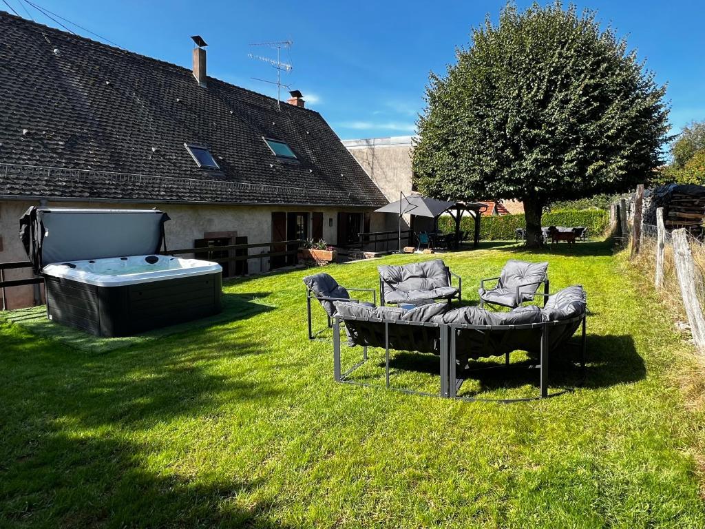 a yard with two chairs and a hot tub at La Buissonnière in Erckartswiller