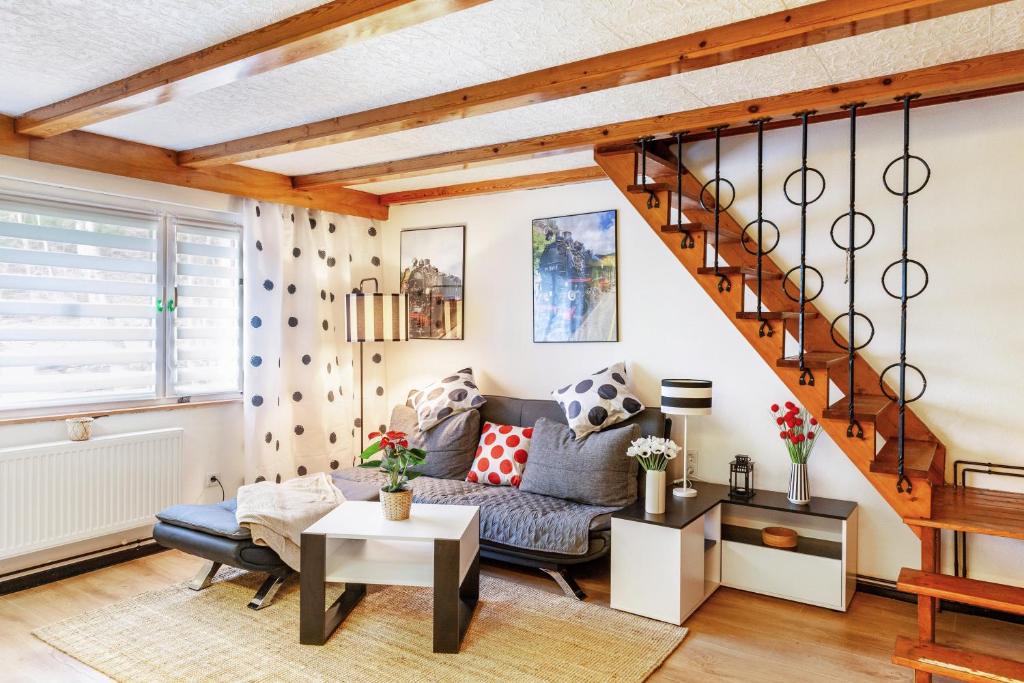 a living room with a blue couch and stairs at Waldhaus zur Kleinbahn in Glashütte