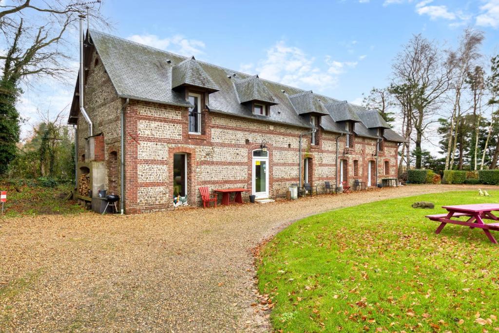 a large brick building with a picnic table in front of it at Clos Des Hogues - Chambres d'hôtes in Saint-Léonard