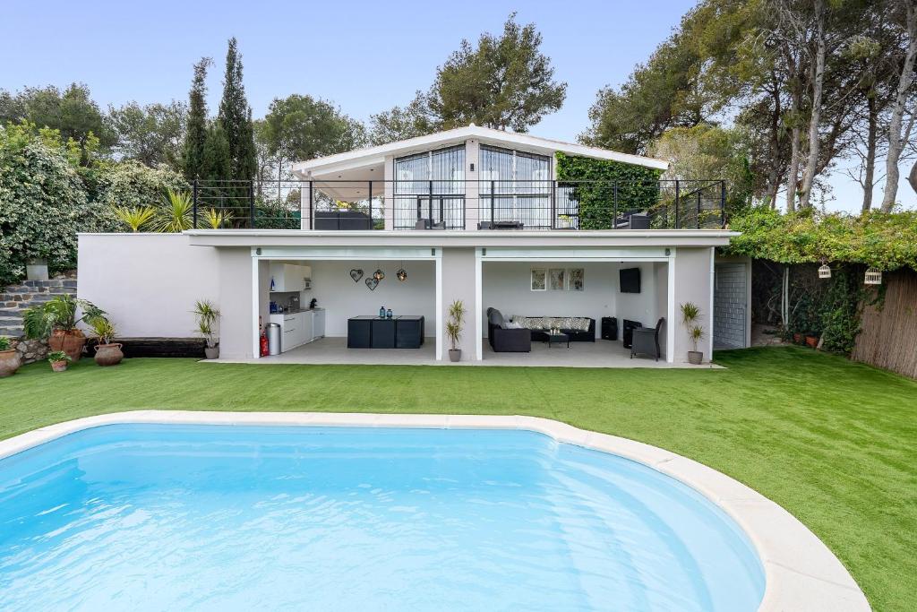 a house with a swimming pool in front of it at Valle de los sueños in Canyelles