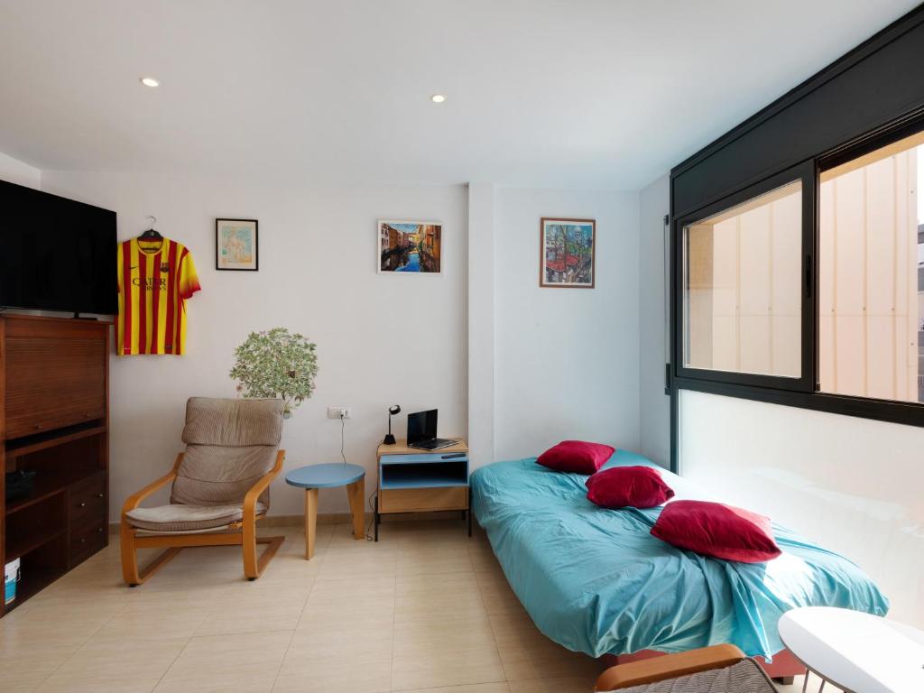 ein Schlafzimmer mit einem Bett mit roten Kissen und einem Stuhl in der Unterkunft Gesmark in Mataró