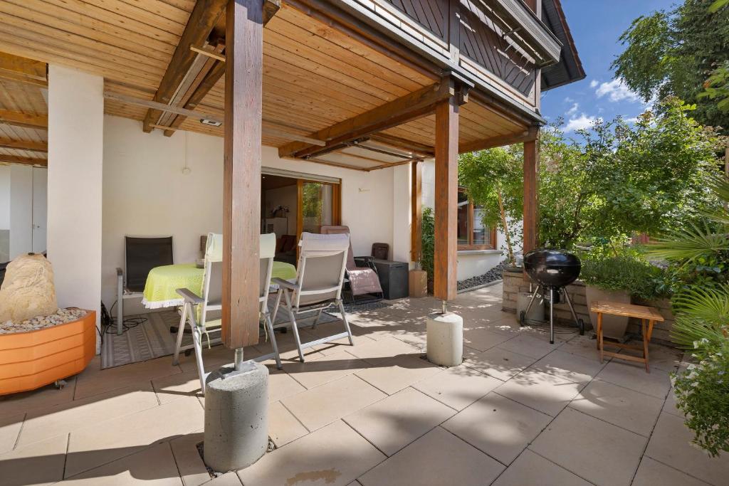 a covered patio with a table and chairs and a grill at Ferienwohnung Janko in Meßstetten