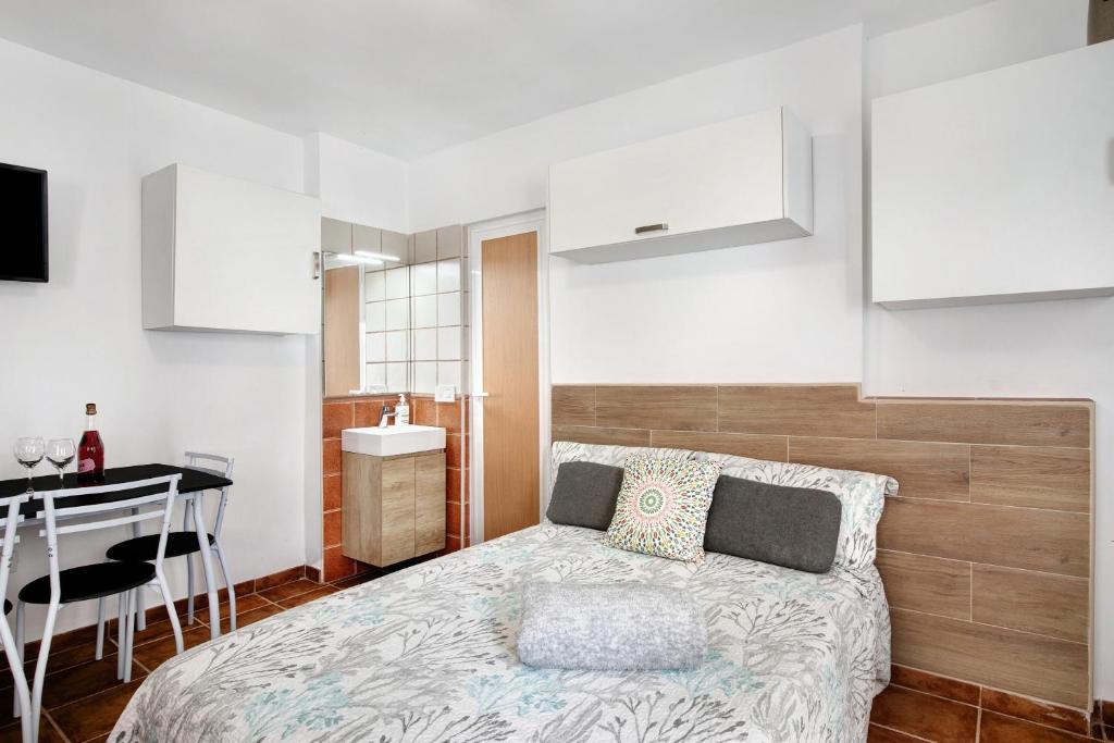 a bedroom with a bed and a desk and a kitchen at Estudio La Morena in El Pris