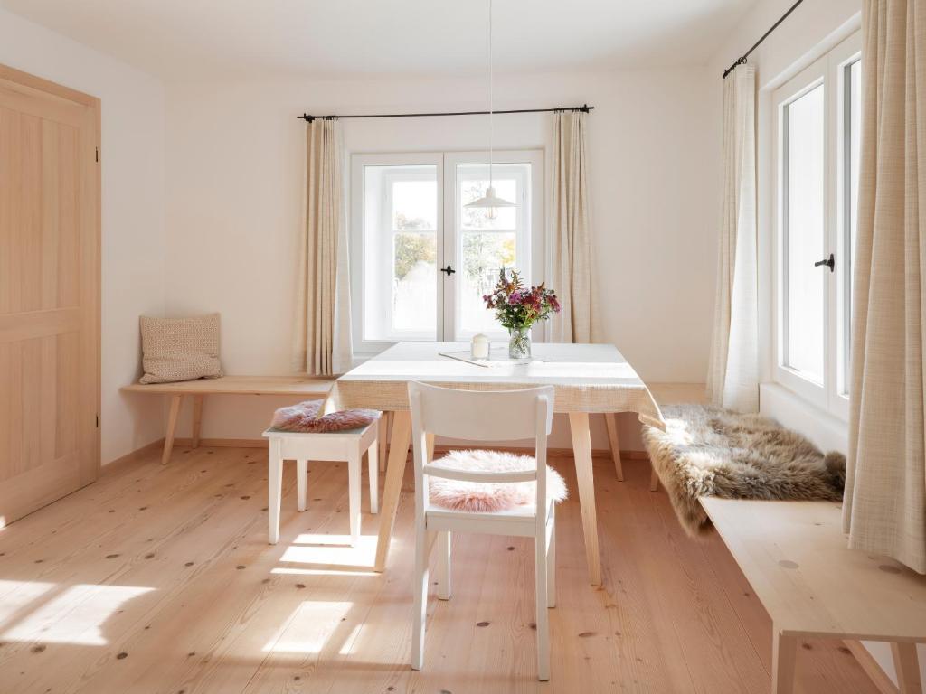 a white dining room with a white table and chairs at Armenhaus 1828 in Görisried