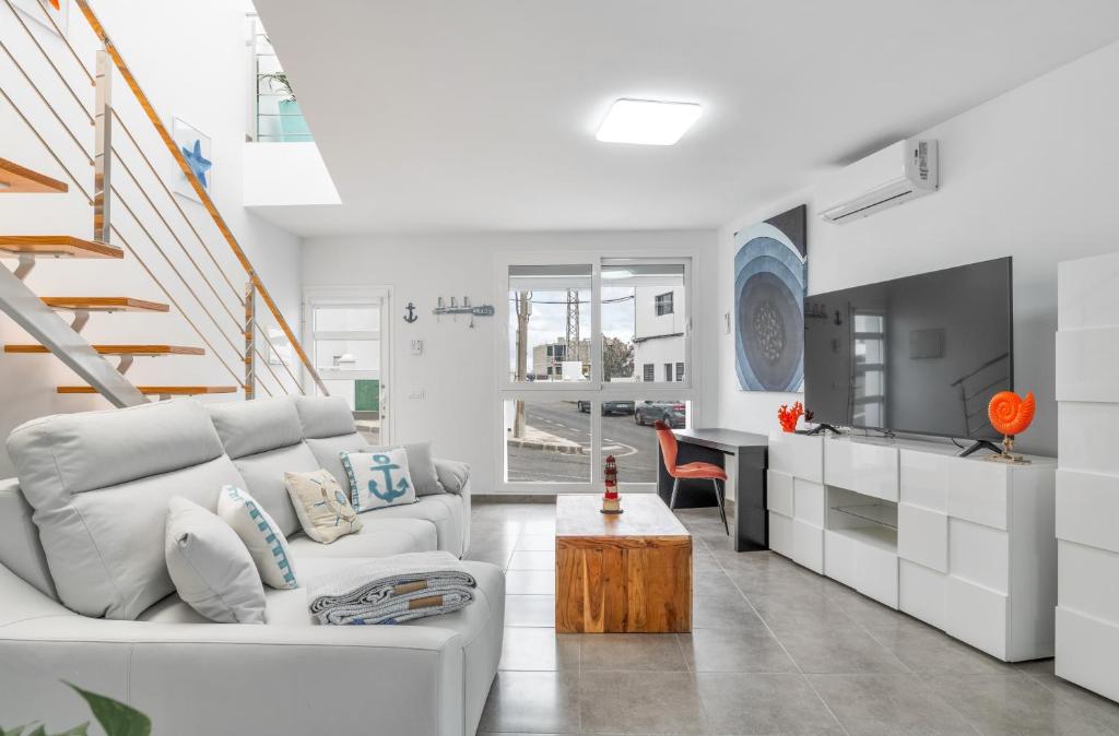 a white living room with a white couch and a table at Sparrow in La Santa