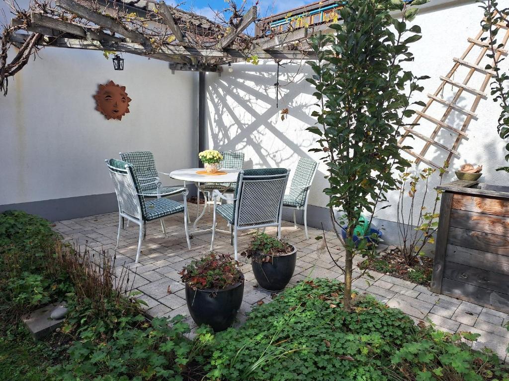 a patio with chairs and a table and a tree at Haus Frank in Wehr