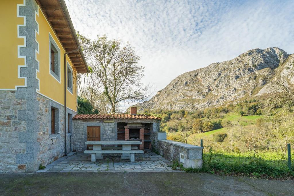 a picnic table outside of a building with mountains in the background at Casa Collado Santo Tomás in El Collado