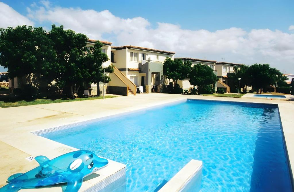 a blue toy dog sitting next to a swimming pool at Tranquilo apto con preciosa cala in Cala en Forcat