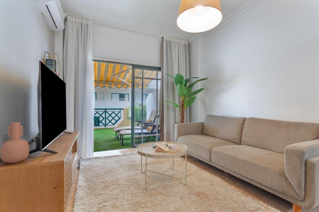 a living room with a couch and a tv and a table at Apartamento Luminoso Con Terraza in Puerto de la Cruz