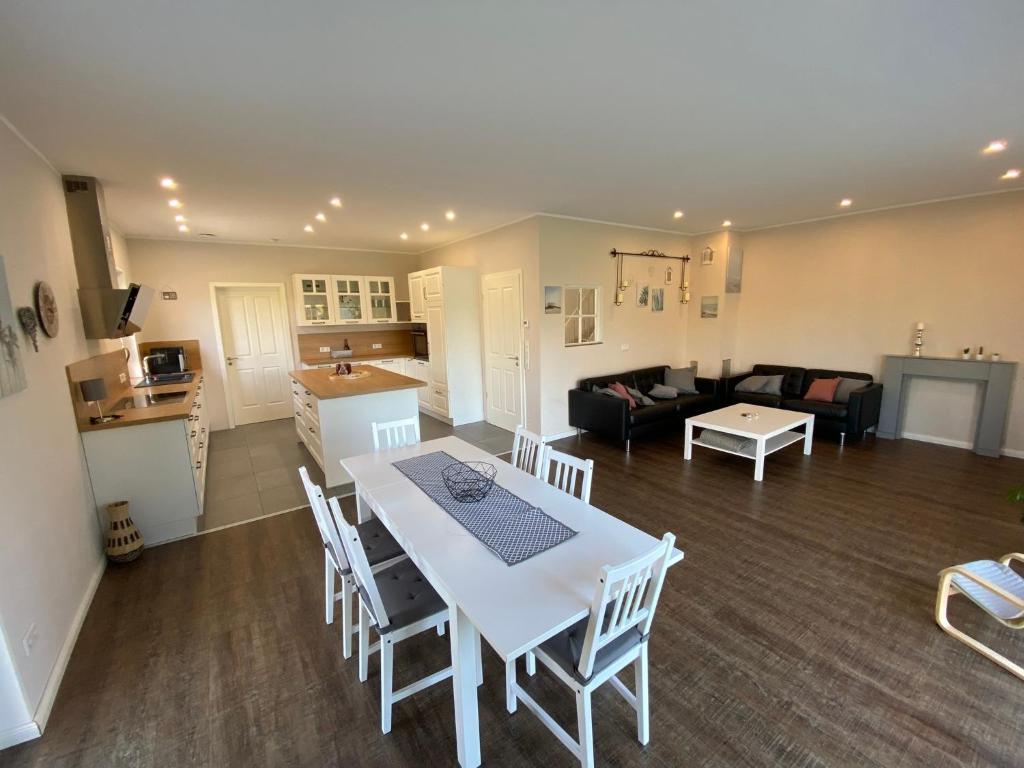 a kitchen and living room with a white table and chairs at Ferienwohnung Repetal in Attendorn