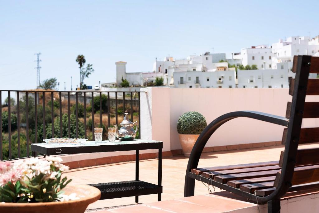 a patio with a bench and a table on a balcony at Cobijadas75 Segur in Vejer de la Frontera