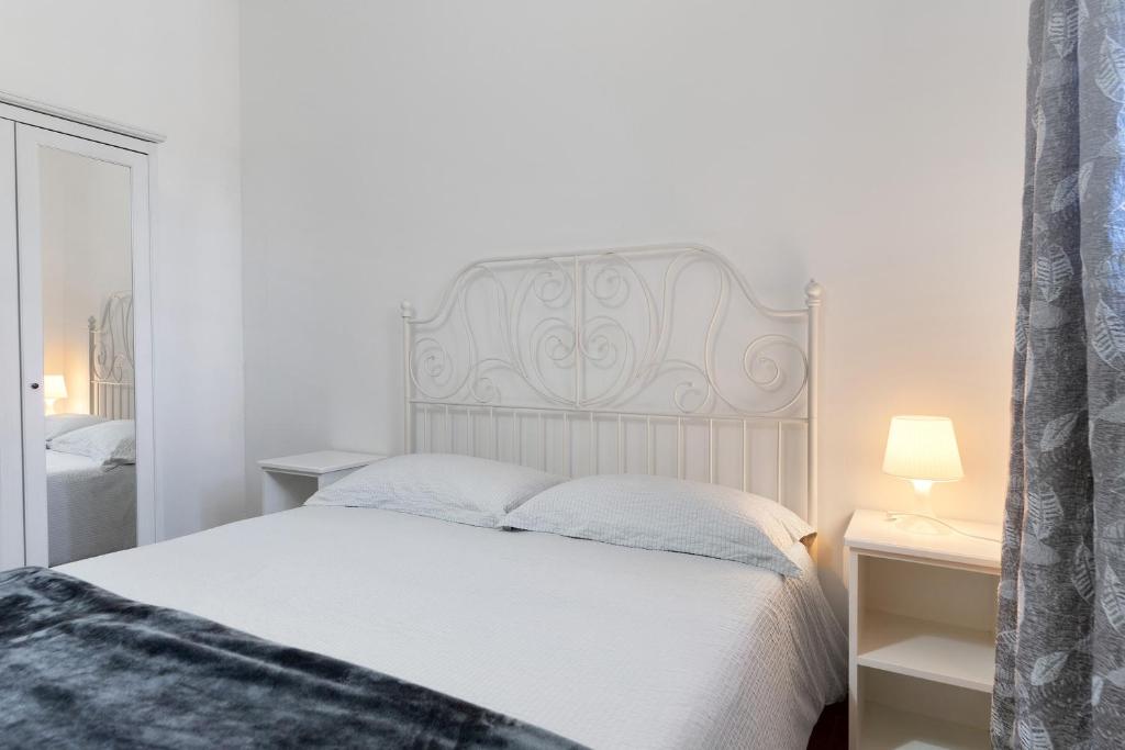 a bedroom with a white bed with a white headboard at Ride Home 2 in Commezzadura