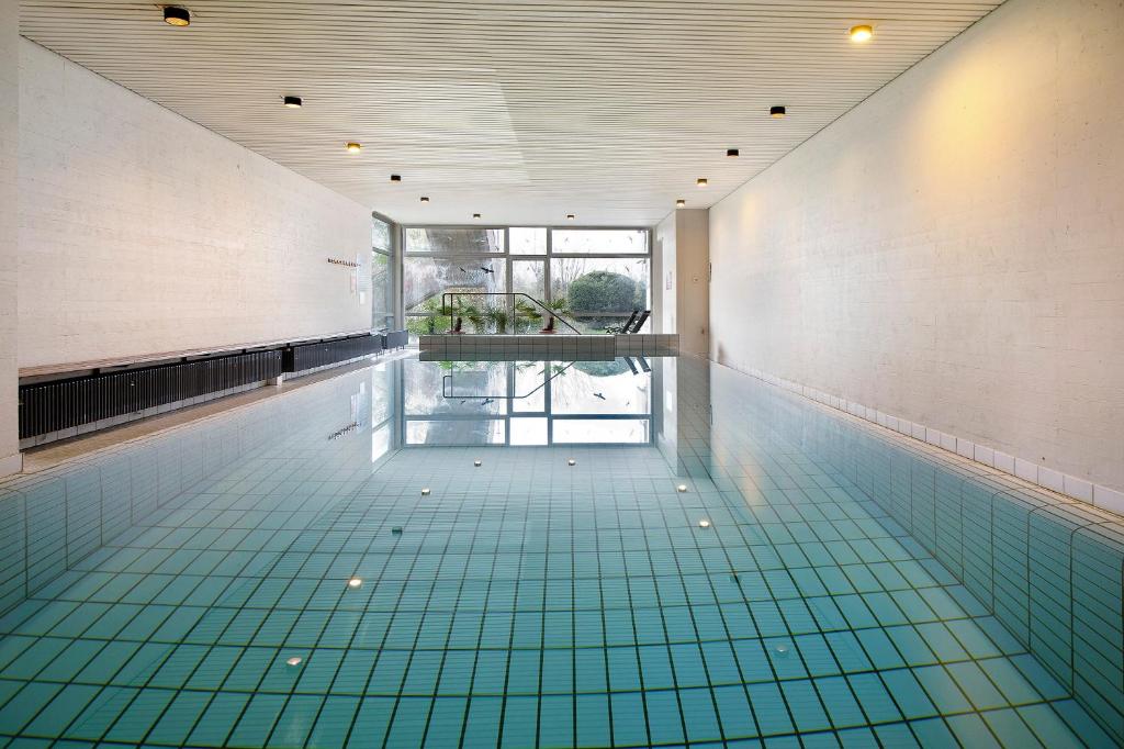 an empty swimming pool with green tile flooring at Blackforest Perla in Höchenschwand