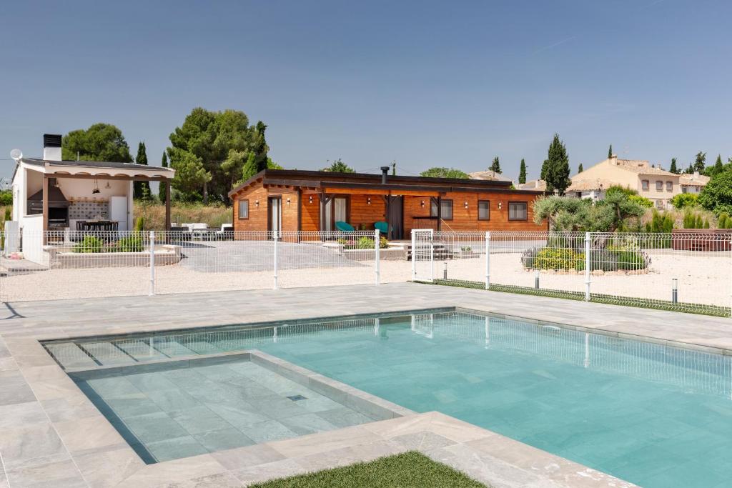 a swimming pool with a building in the background at Cortijo la Jimena 2 in Benablón