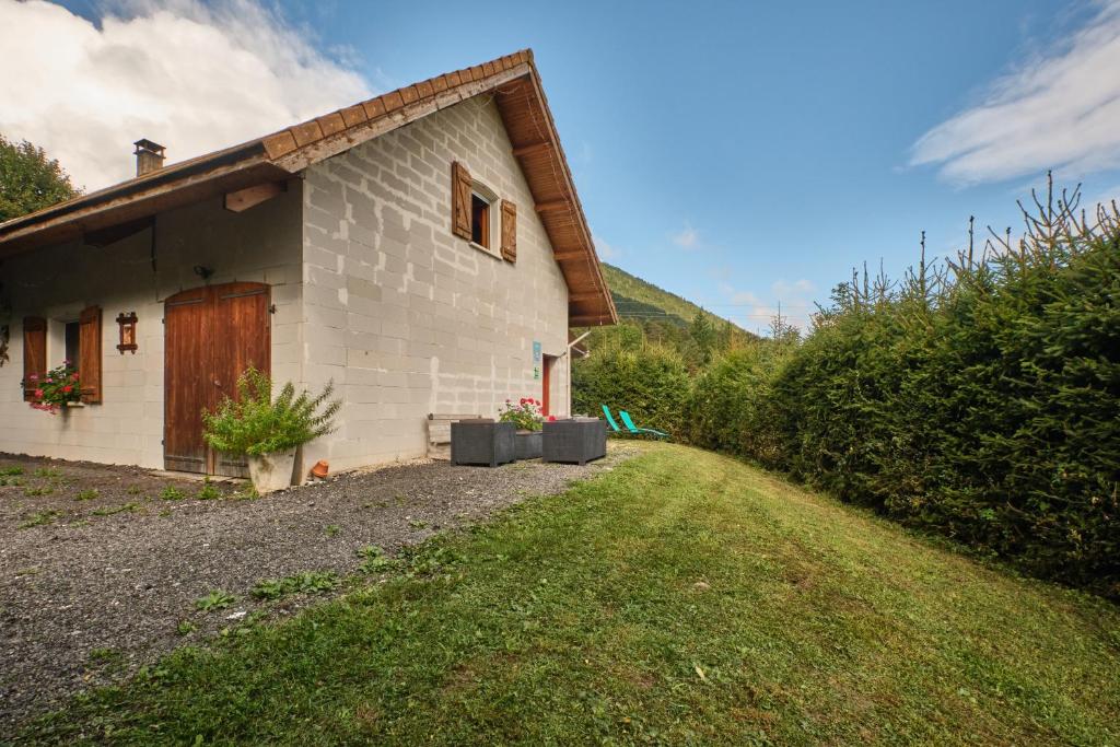 a small house with a grass yard next to a building at Gite des Granges in Tréminis