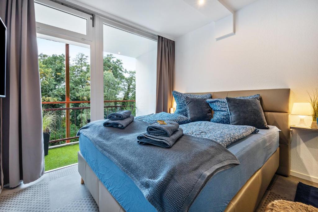 a bedroom with a bed with blue sheets and a window at Steuermann am Steinhuder Meer in Wunstorf