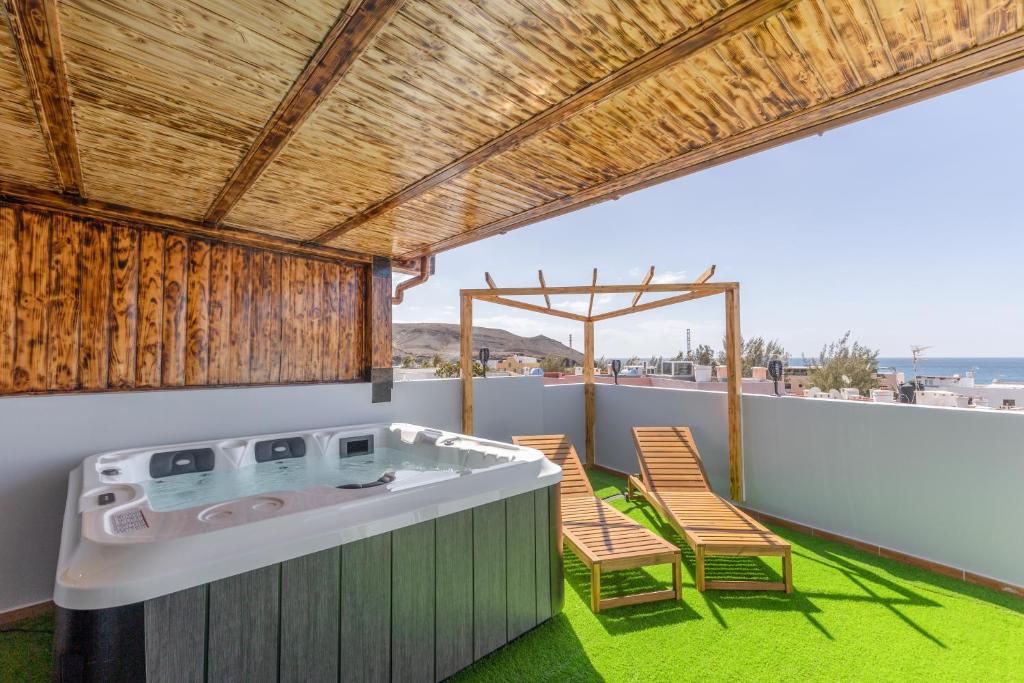 a hot tub on a balcony with two chairs at Terra Nova Penthouse in Lajita